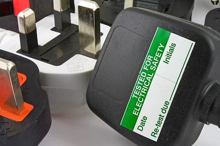 Group of electrical plugs including one marked with an electrical safety test label